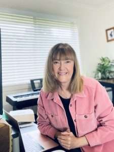 A photo of Helen Calder sitting at her desk